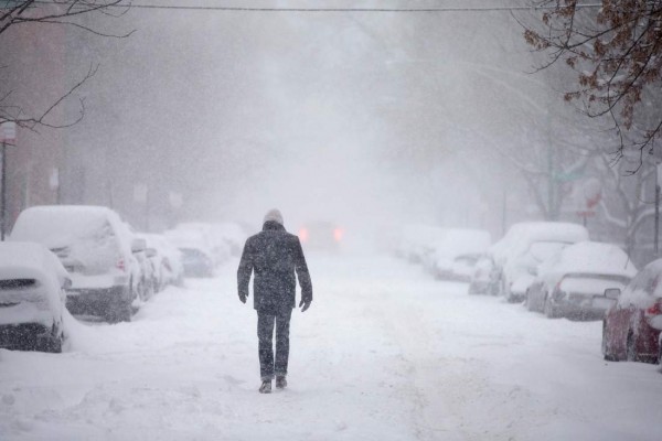 CHICAGO, IL - FEBRUARY 01:  A man walks down a snow-covered street on February 1, 2015 in Chicago, Illinois. Fifteen inches or more of snow is expected to fall on the city before Monday morning. The snow has caused power outages and forced about 2,000 flight cancelations at the city's airports. (Photo by Scott Olson/Getty Images)